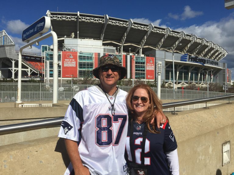 Chris and his wife in Patriots jerseys at the stadium